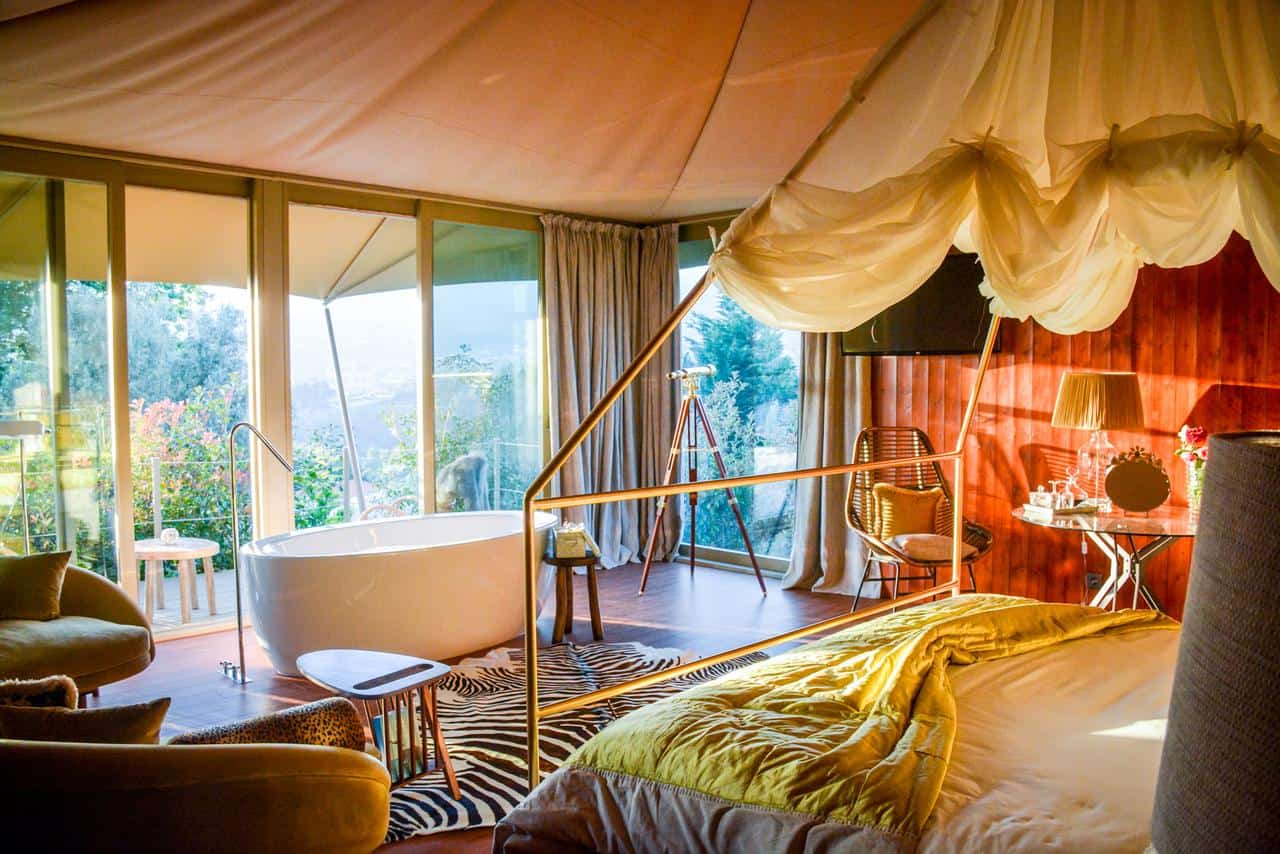 Elegant hotel room with a canopy bed and scenic views for cycling enthusiasts.