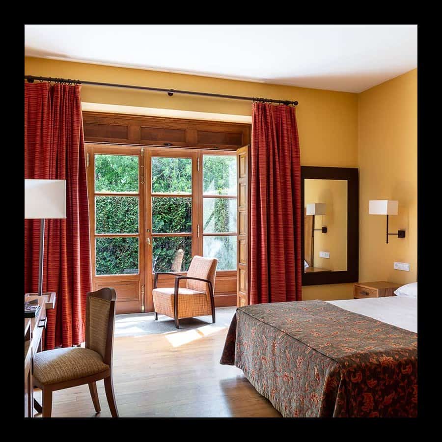 Interior view of a hotel room at Parador de Tui with a large window and comfortable seating.