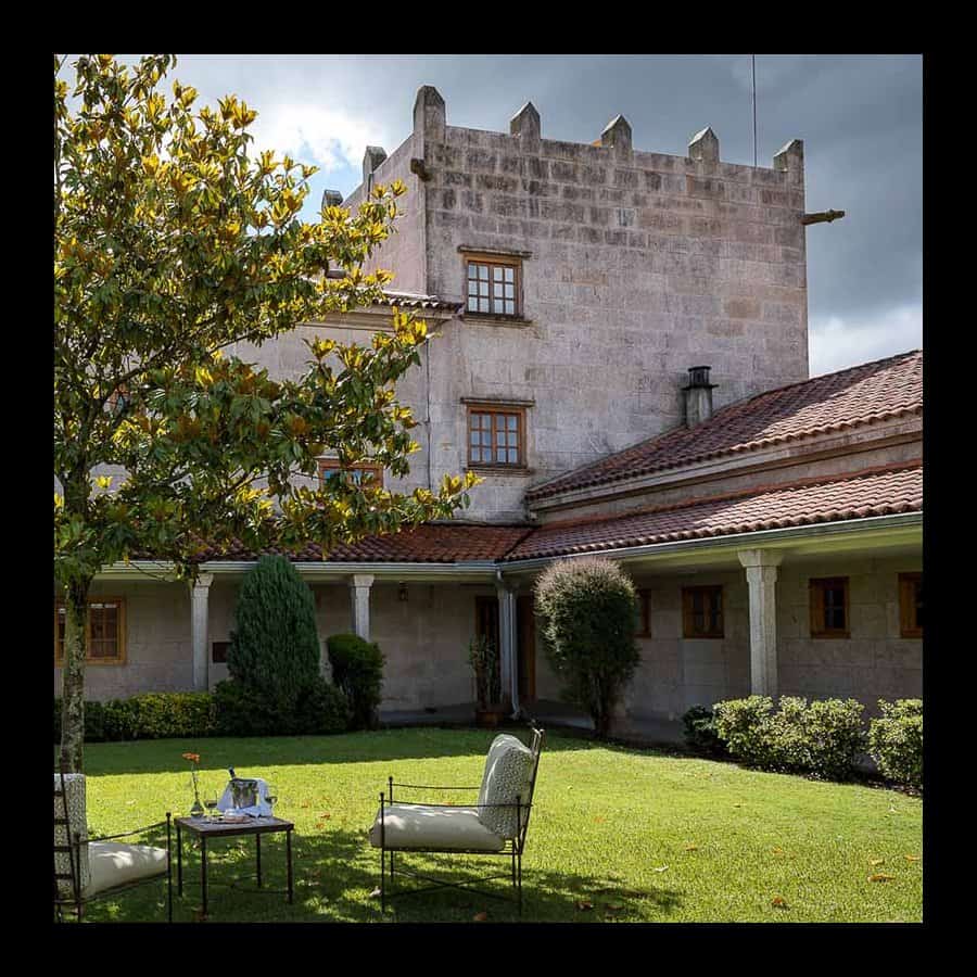 Historic castle hotel with lush garden and outdoor seating in Tui, Galicia. Perfect for cycling tour.