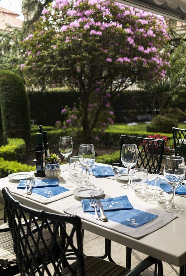 Outdoor dining setup with wine glasses and blue napkins at Parador de Pontevedra.