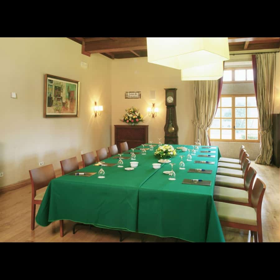 Elegant meeting room at Parador de Tui with a long table set for a conference.