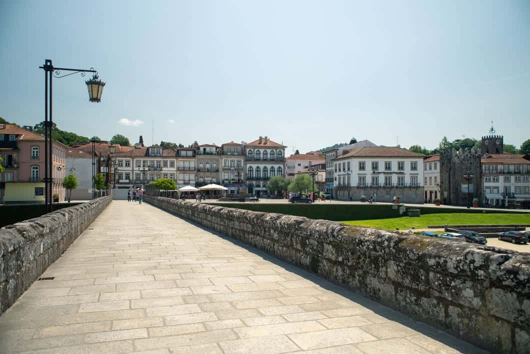 Hiking by Ponte de Lima's medieval bridge, you take in the historic center's rooftops and spires, framed by the serene flow of the Lima River and lush green banks.