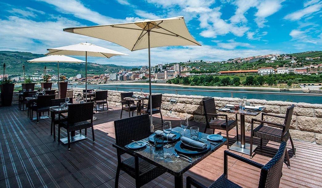 Outdoor dining with river view at Vila Galé Collection Douro, perfect for cycling and exploring Port.
